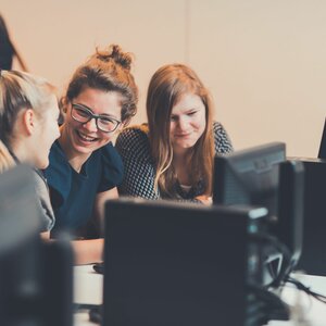 3 studenten aan een computer in een leslokaal