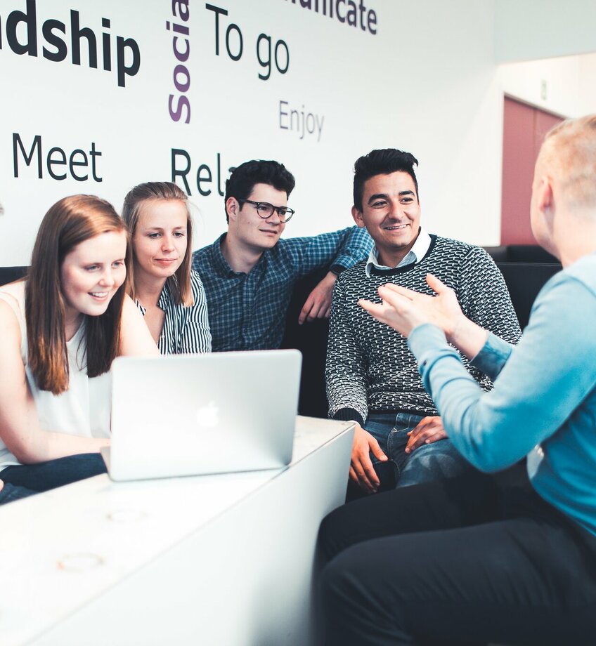 Studenten zitten rond tafel aan laptop