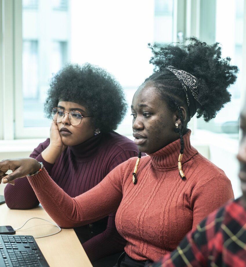 Drie buitenlandse studenten aan een computer