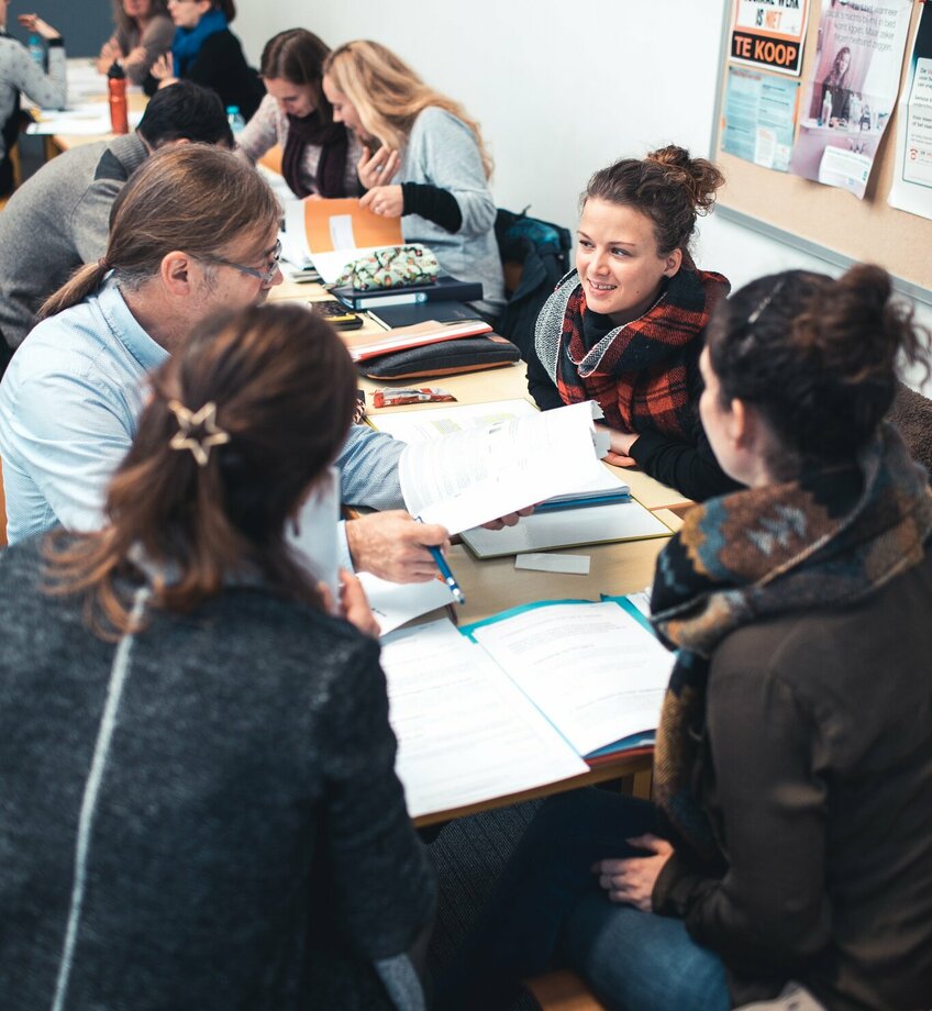 Volwassen studenten aan een tafel