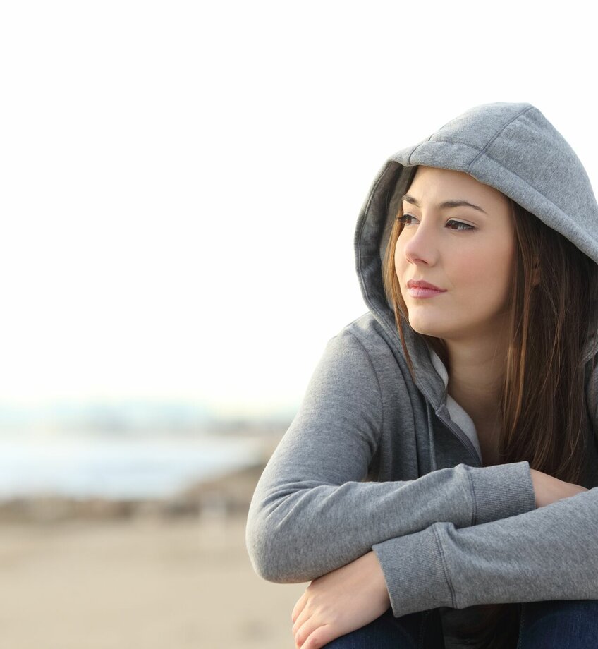 Jonge vrouw kijkt uit over het strand