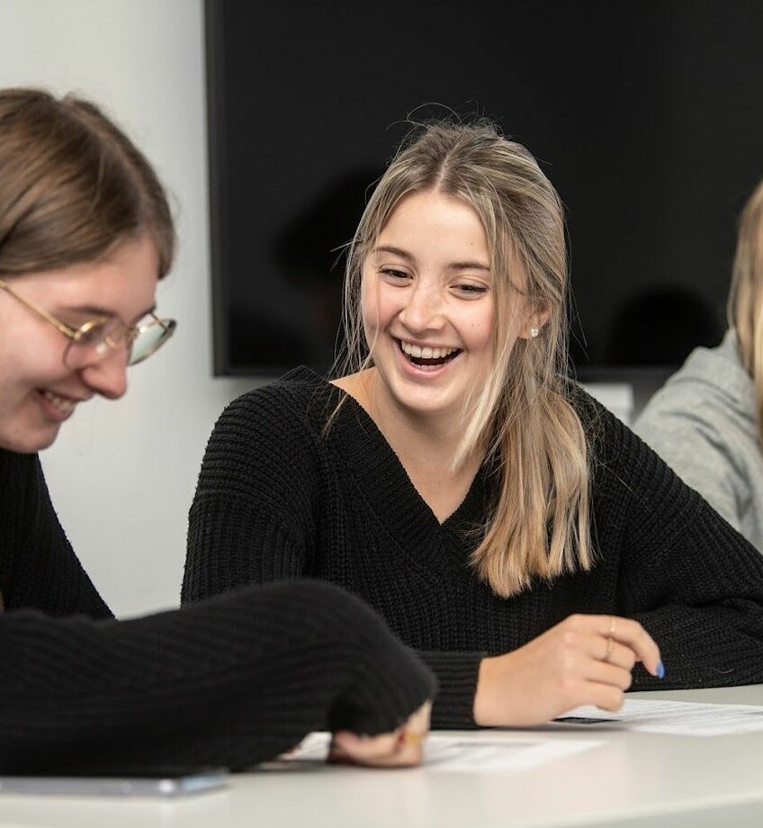 2 studenten die samen zitten en lachen