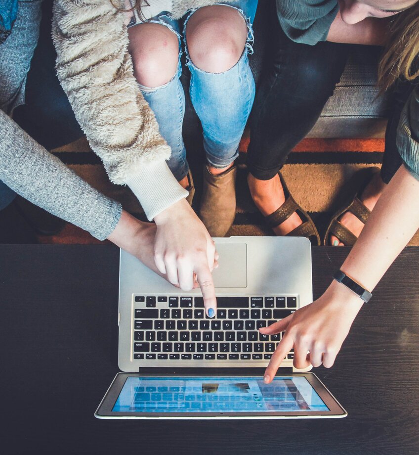 3 studenten zitten aan een laptop.