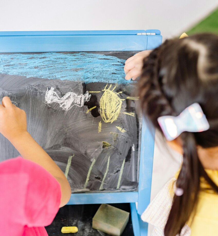 Girls Drawing on a Blackboard