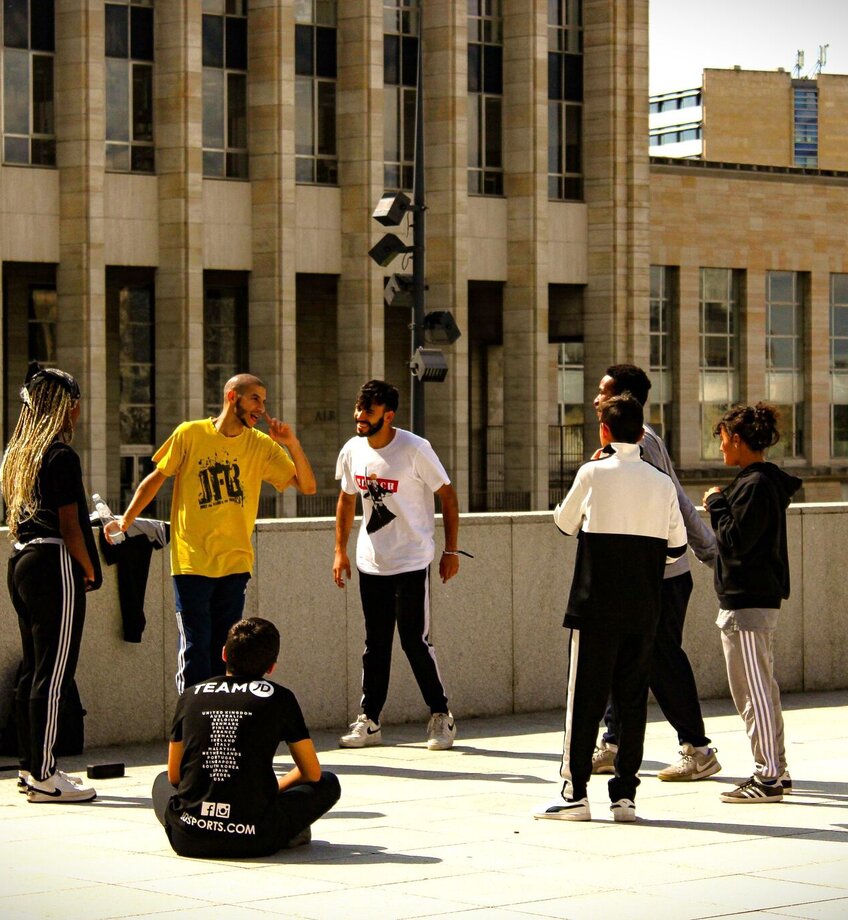 A group of friends casually hanging out on a rooftop in Brussels, Belgium, enjoying the sunny day