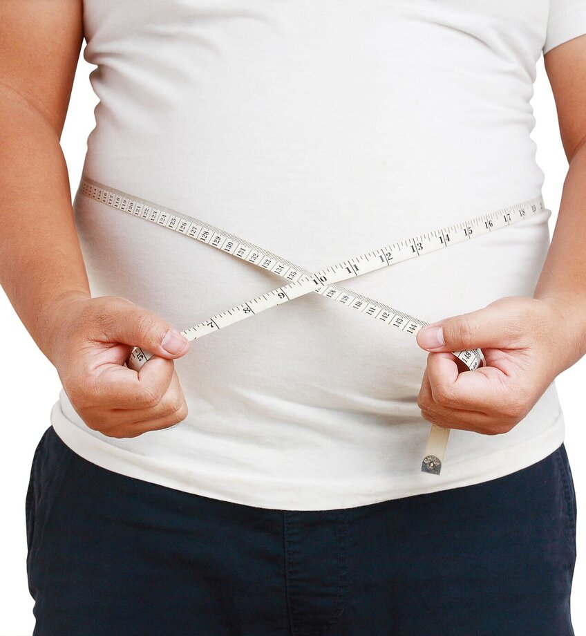 fat man using a tape measure around his waist