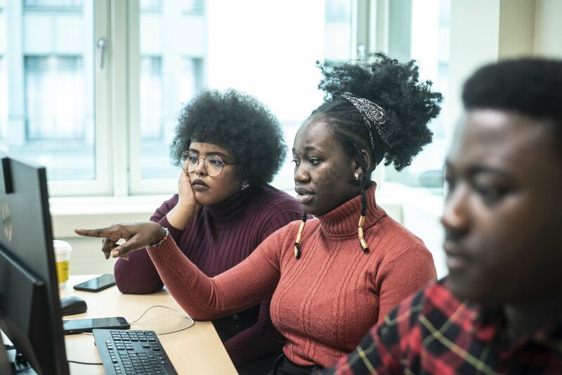 Drie buitenlandse studenten aan een computer