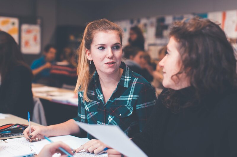 Studenten met papier en balpen