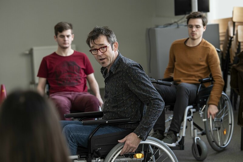 docent geeft studenten uitleg over rijden met rolstoel