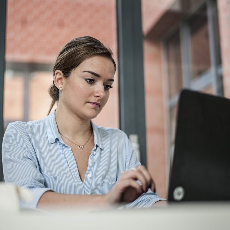 Jonge vrouw tikt op computer