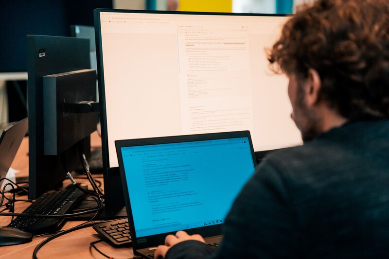 een student programmeren maakt gebruik van een tweede monitor in ons labolokaal