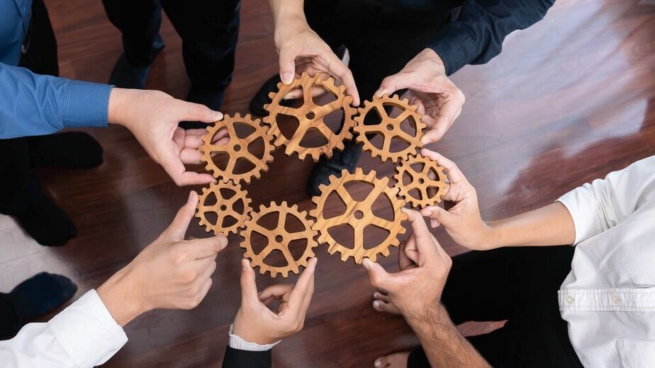 Business team joining cogwheel in circular together symbolize successful group of business partnership and strong collective unity teamwork in community workplace with productive efficiency.