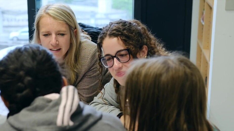 A teacher and a student teacher supporting a small group of pupils together