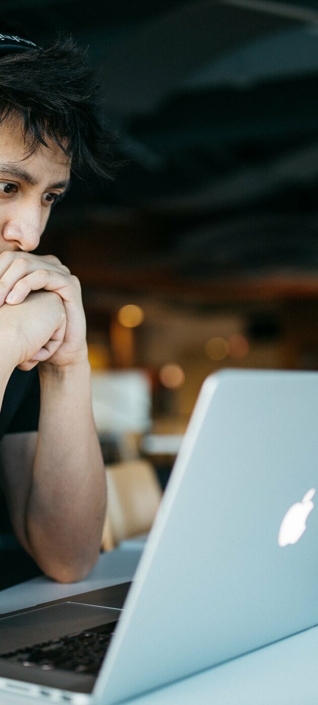 jongen met hoofdtelefoon kijkt naar laptop