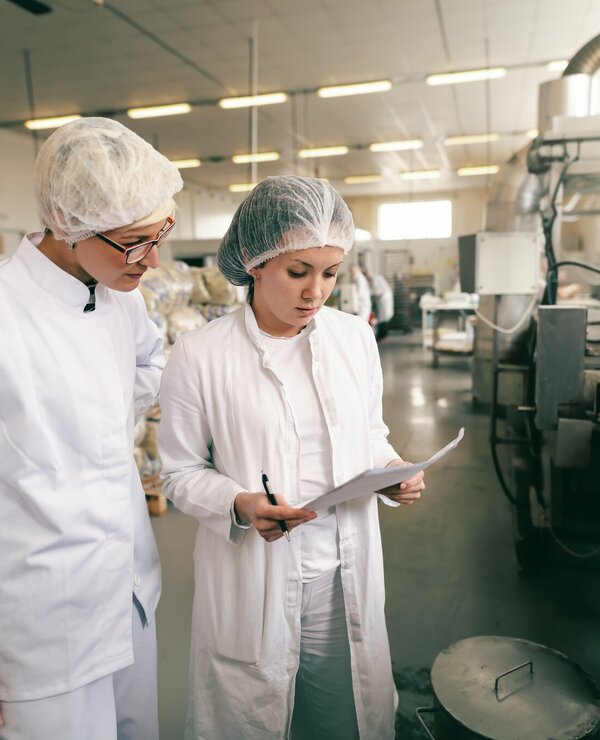 Twee kwaliteitsprofessionals in een voedingsfabriek